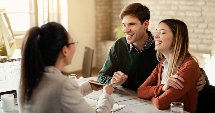 Couple laughing and smiling during consultation in office space.